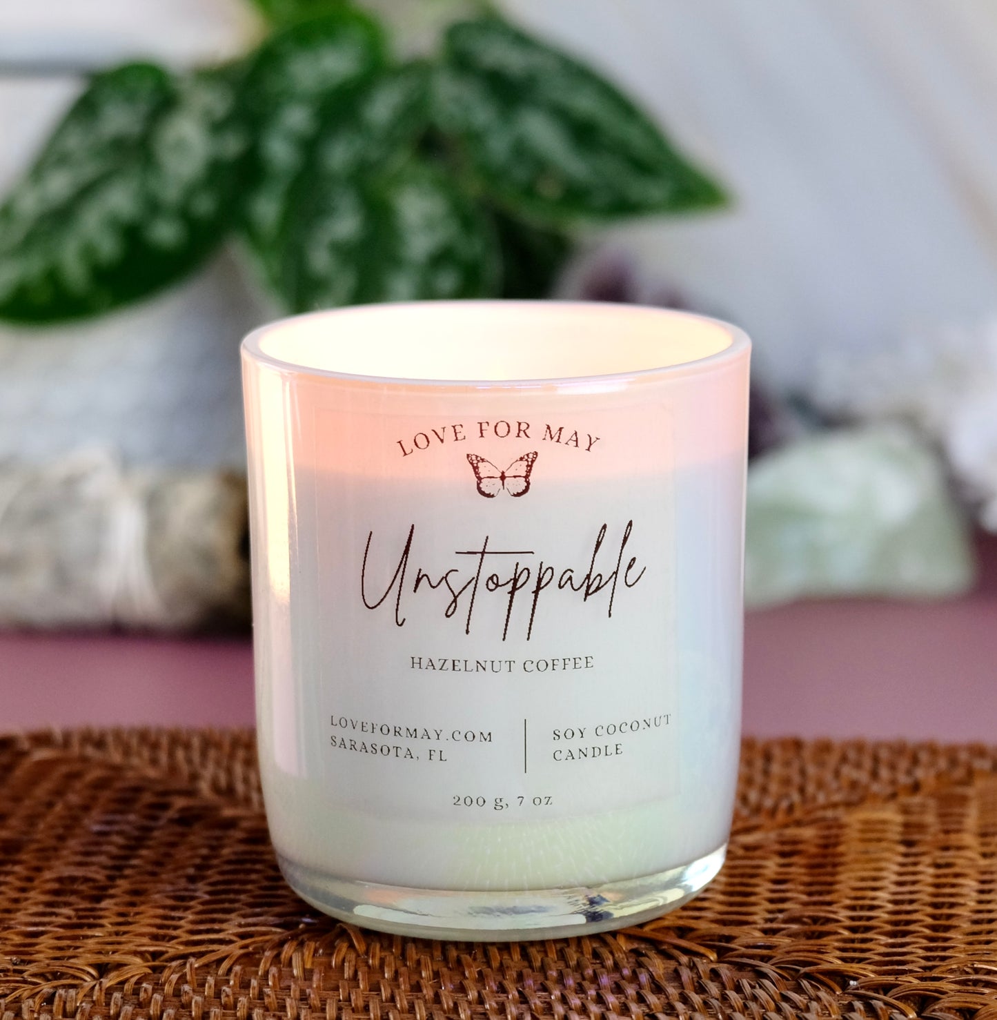 Iridescent manifestation candle with the word Unstoppable on the label