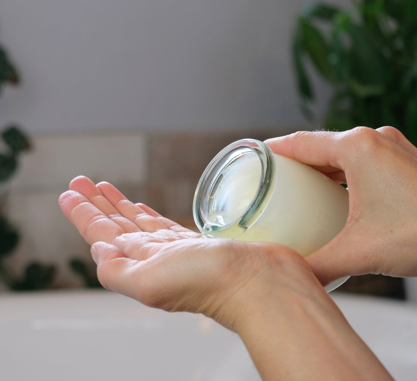 Hands pouring the melted wax from a body oil candle
