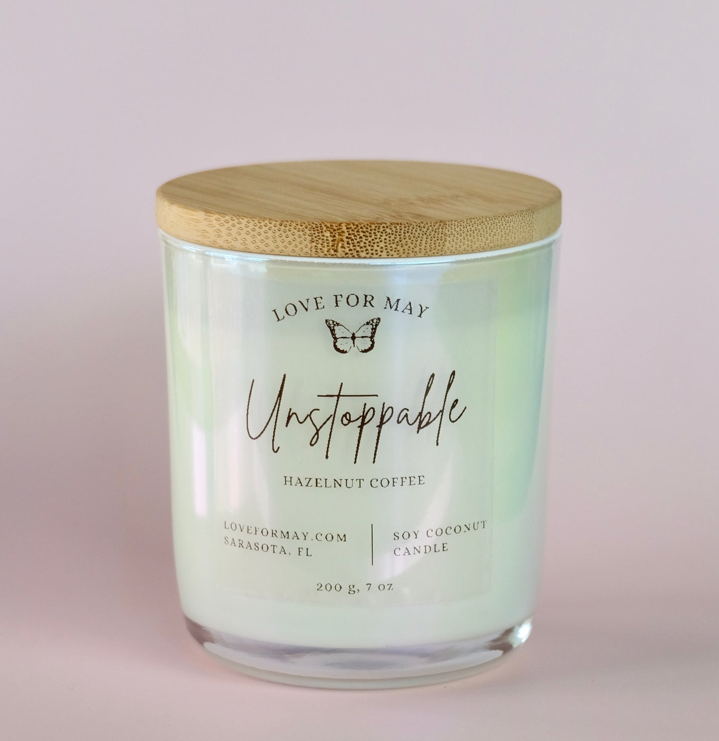 Hazelnut Coffee scented candle in a white iridescent glass jar with a bamboo lid and the word unstoppable on the label.
