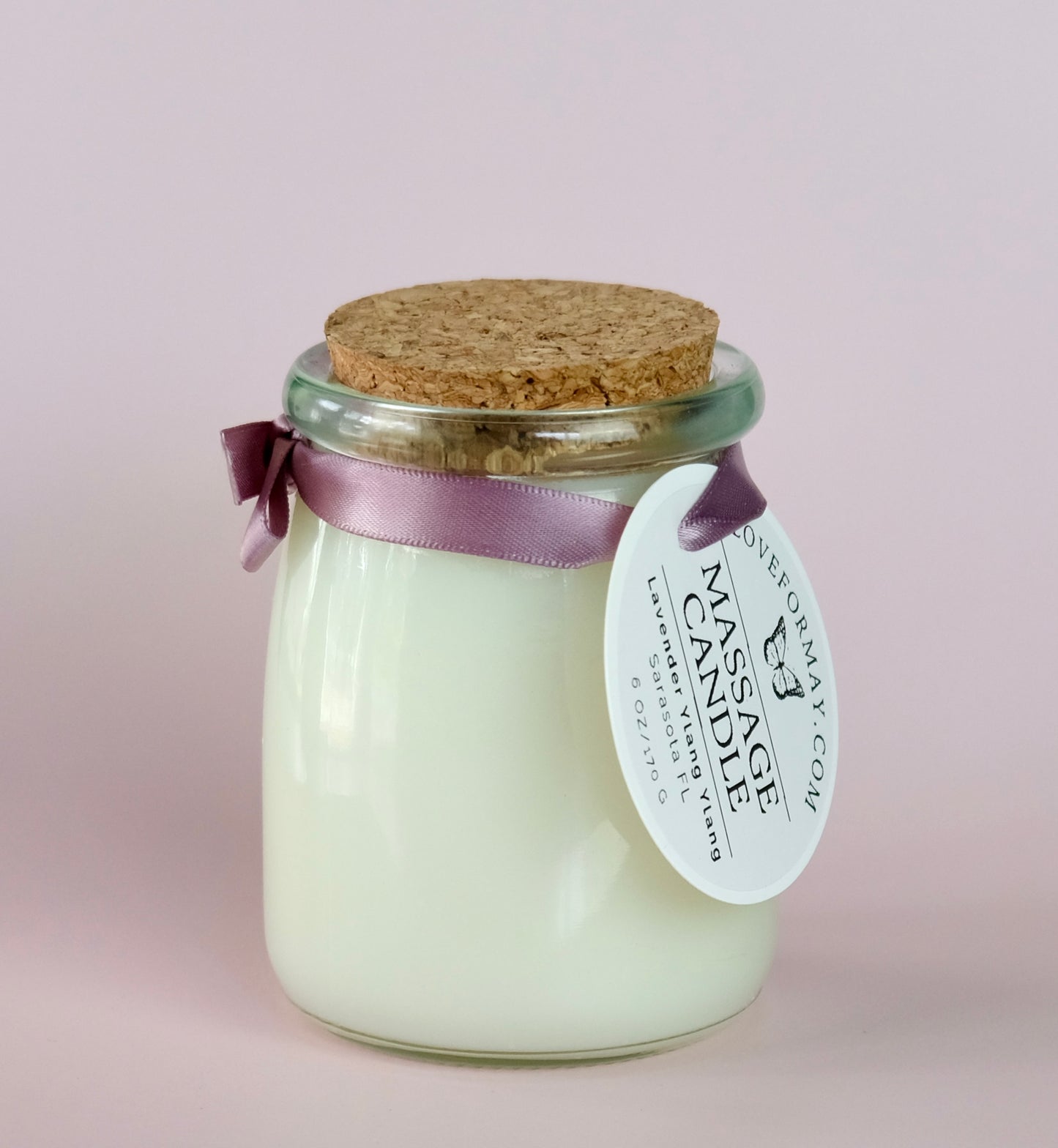A handmade massage candle in a glass jar with a cork lid scented lavender ylang ylang