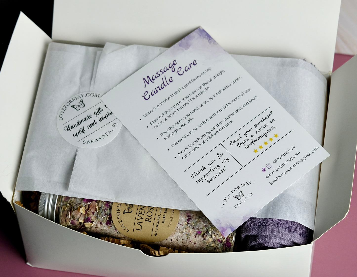 Beautifully packaged gift box with candles, bath tea, and purple wash cloth. Includes instructions for a massage candle.