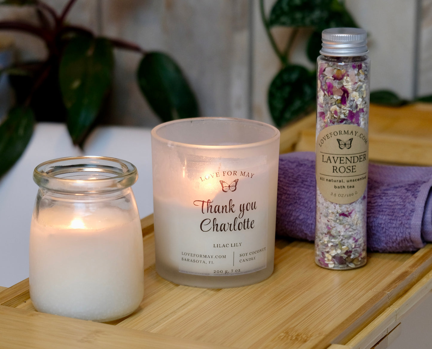 Gift set on bath caddy with massage candle, personalized thank you candle, bath tea, and wash cloth.