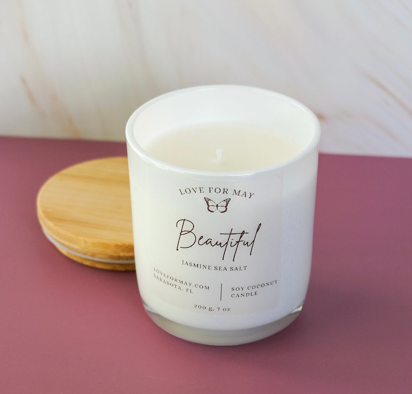 Jasmine Sea Salt scented candle in a frosted glass jar with the word beautiful on the label.