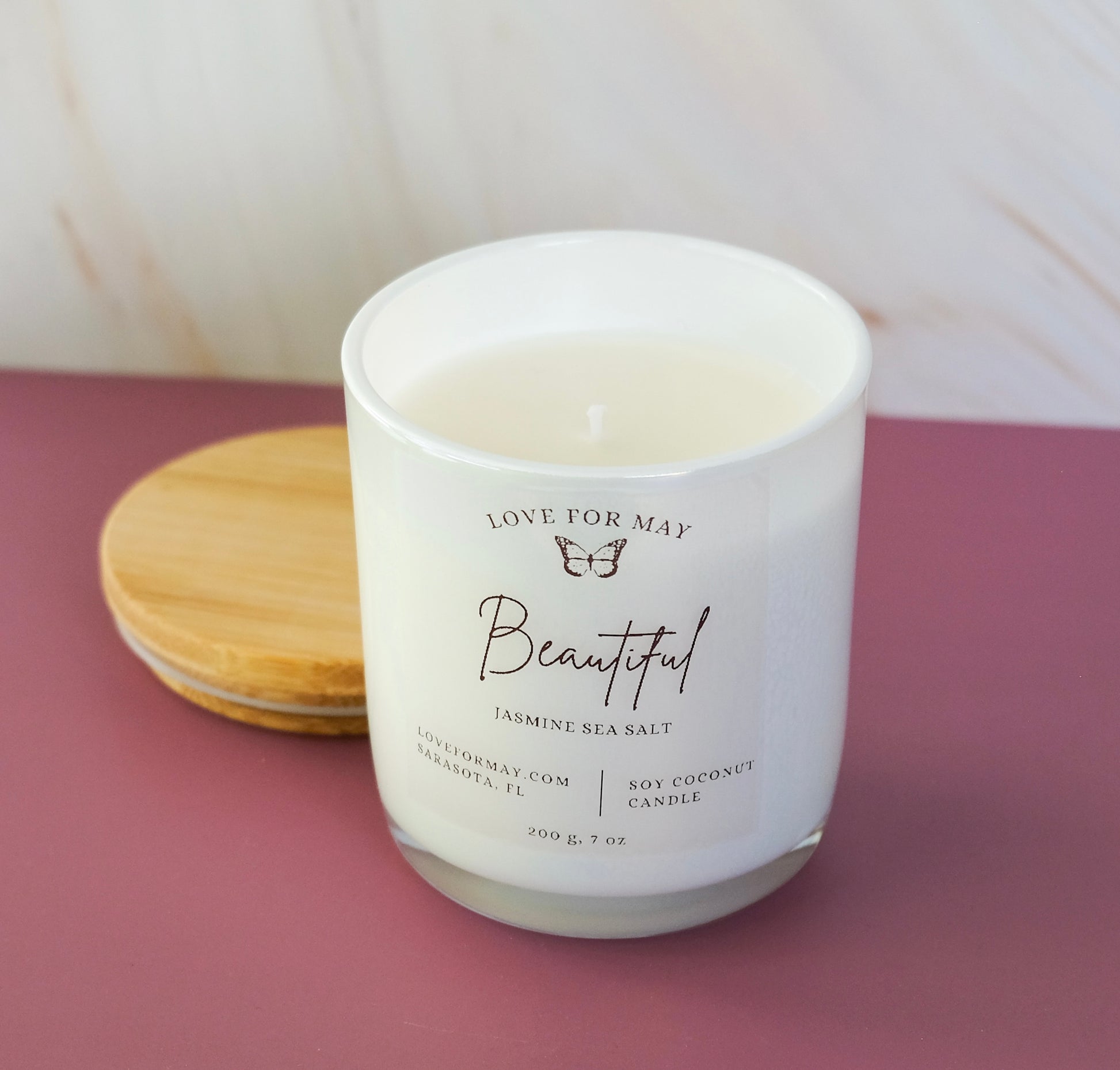 Jasmine Sea Salt scented candle in a frosted glass jar with the word beautiful on the label.