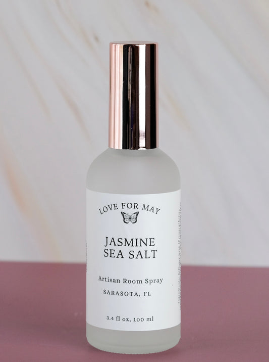Room spray scented jasmine sea salt in a frosted glass bottle with rose gold lid.