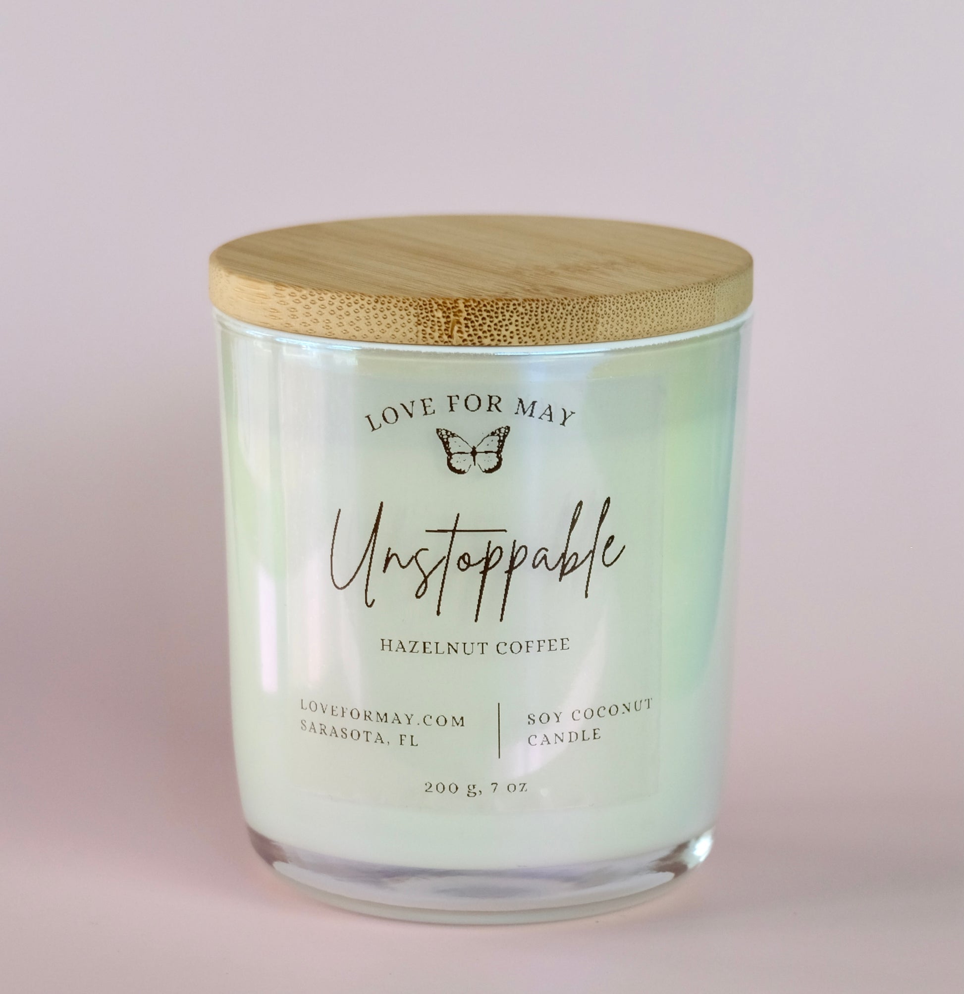 Hazelnut Coffee scented candle in a white iridescent glass jar with a bamboo lid and the word unstoppable on the label.