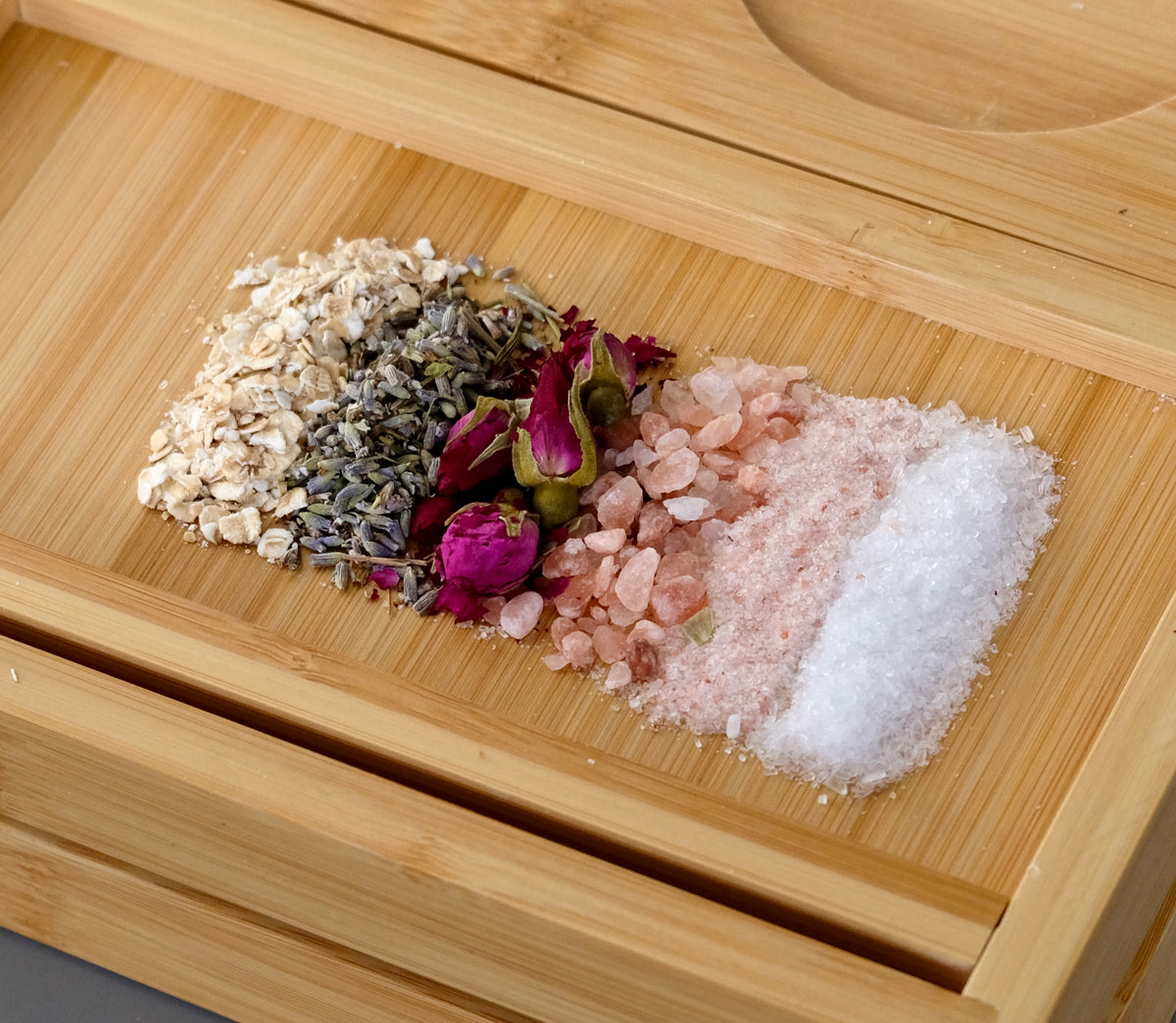 Bath salts and dried flowers on a wooden tray