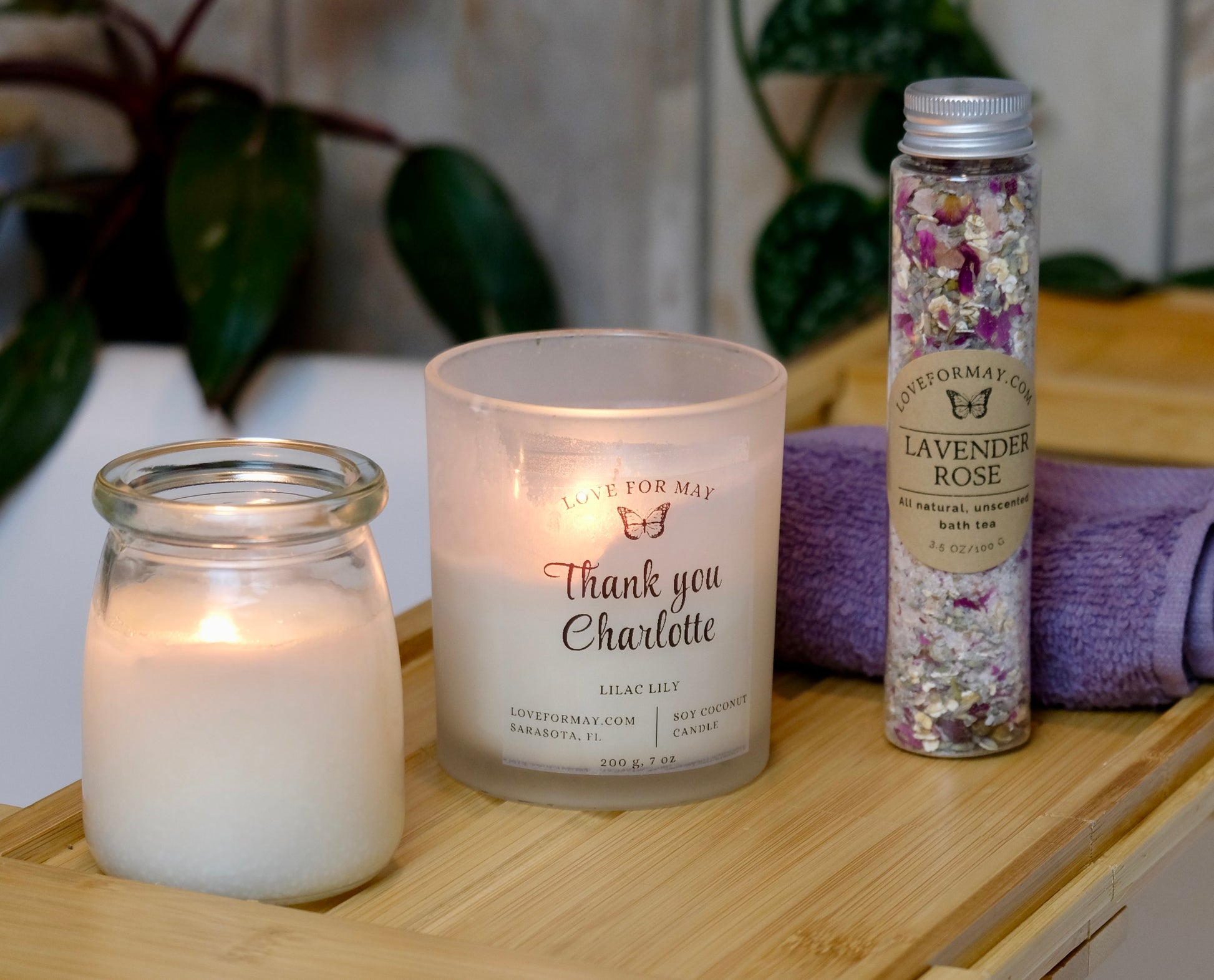 Gift set on bath caddy with massage candle, personalized thank you candle, bath tea, and wash cloth.
