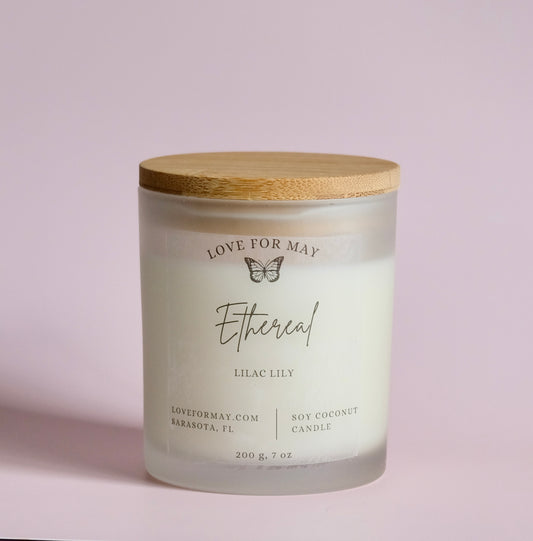 Handmade manifestation candle with a wooden lid and the word ethereal on the label 