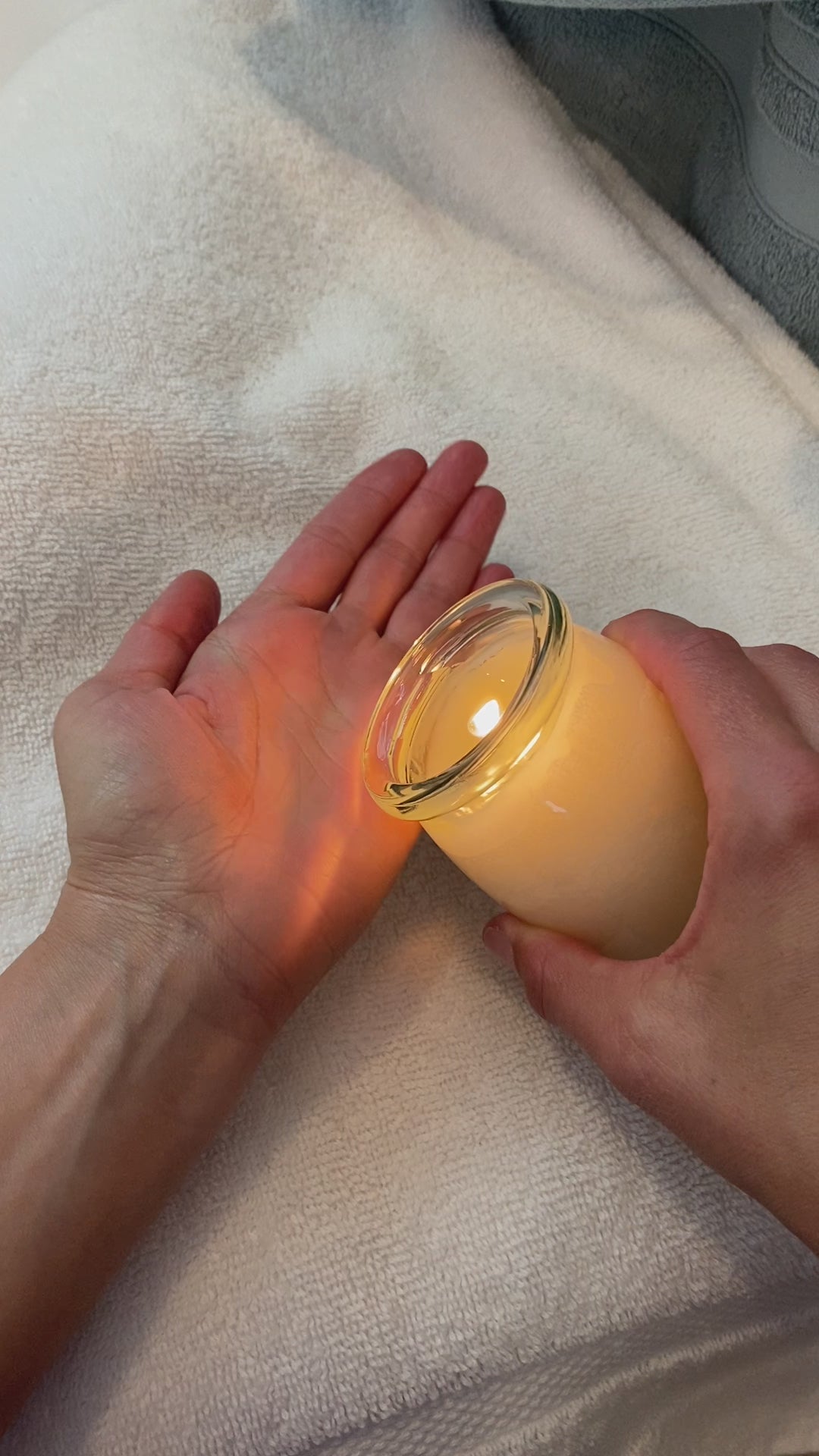 Video of hands pouring the melted wax from a body oil candle and massaging it onto hands and arms