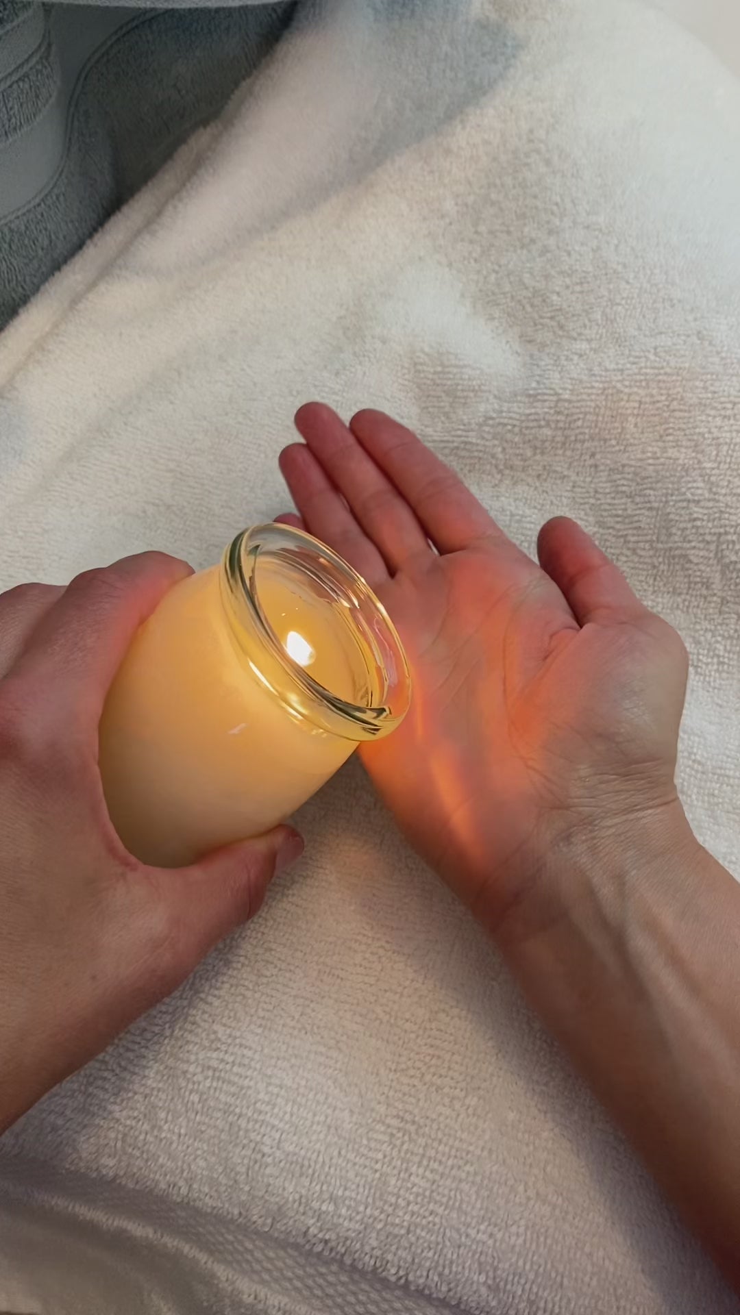 Pouring oil from a massage candle into hands and massaging hands and arm.